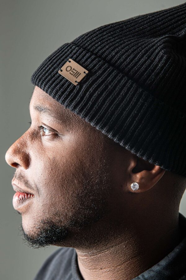 detailaufnahme: OSM logo auf veganem kaktusleder-patch der schwarzen beanie