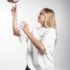 Game Day Heavy Tee side – Seitenansicht des Models, wie sie einen Basketball auf ihrem Finger dreht