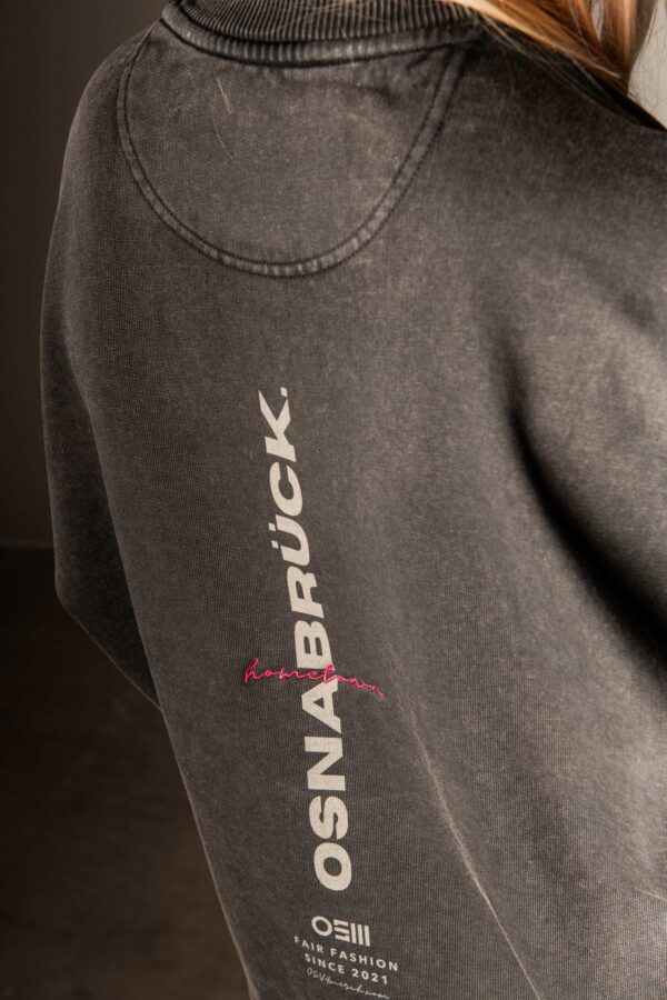 Detailansicht Rückprint „osnabrück“ mit pinkem „hometown“ stick auf schwarzem Sweatshirt
